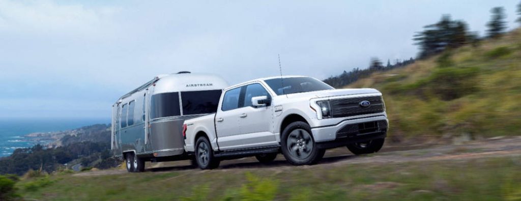 The Ford F-150 Lightning towing a large camper trailer